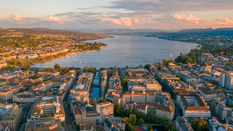 aerial view of city buildings near body of water during daytime