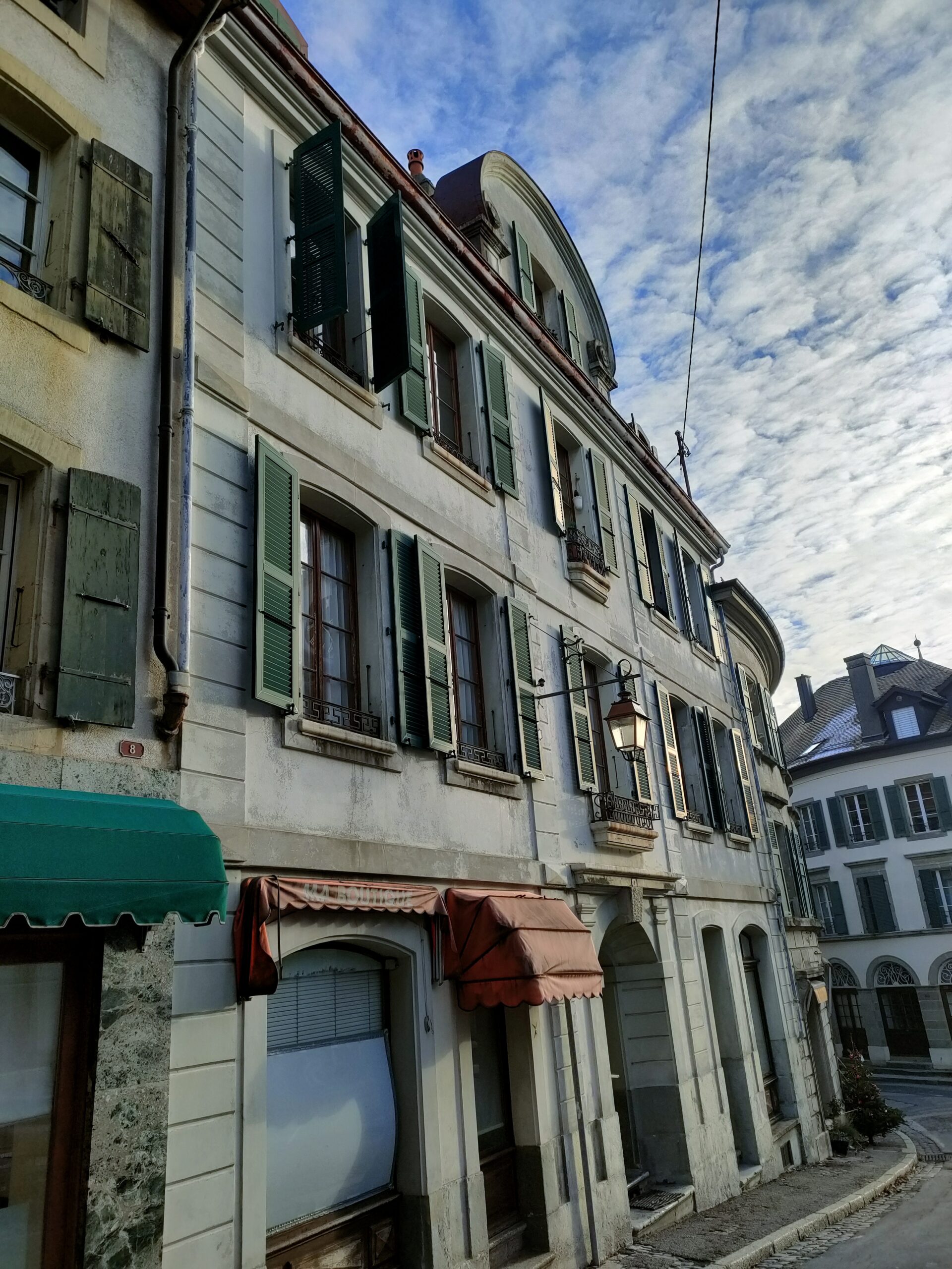 Façade du bâtiment ancien à logements et commerce étudié à Aubonne